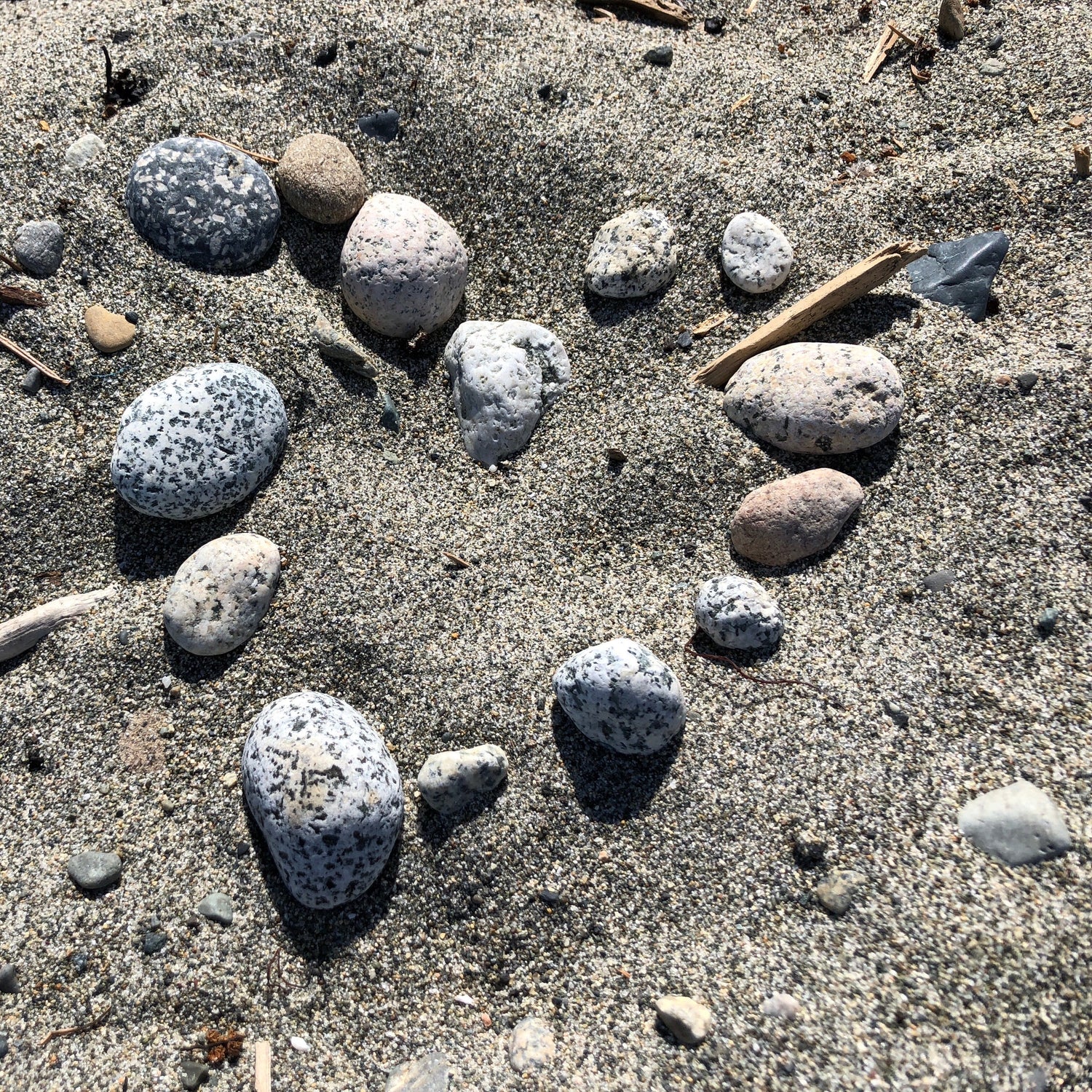 Stones placed in the shape of a heart on sand